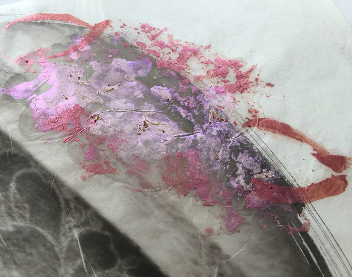 Detail of roses painted on the palladium print of a moth wing with flower tattoos on a woman's arm